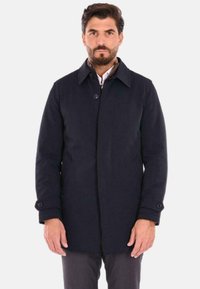 Cappotto blu navy con chiusura a bottoni, due tasche laterali e colletto a punta. Realizzato in tessuto liscio con una vestibilità su misura.