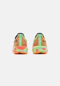 Zapatillas de correr de colores brillantes con patrones de camuflaje en verde neón, naranja y azul, mostradas desde atrás sobre un fondo blanco liso.
