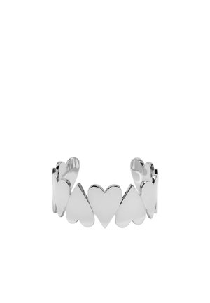 Pulsera de brazalete de plata con una serie de formas de corazón pulidas entrelazadas. La textura suave y el diseño abierto ofrecen flexibilidad.