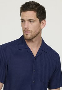 Korte mouwen shirt in marineblauw met een gestructureerd gestreept patroon, een klassieke kraag en een patch pocket, voorzien van zwarte knopen en een ontspannen pasvorm.
