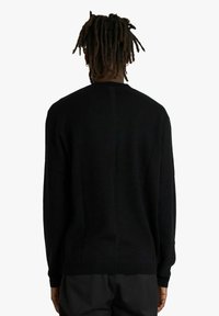 Maglione nero, tessuto lavorato a maglia, collo rotondo, maniche lunghe, vestibilità rilassata, texture liscia, design minimalista, senza motivi o accenti visibili.