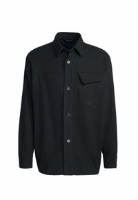 Čierna košeľa s dlhým rukávom na gombíky s špicatým golierom a náprsníkom s klopou, obsahujúca nenápadné vyšívané logo na ľavej strane.