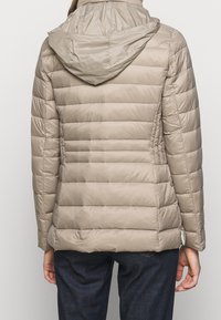 Beige vadderad jacka med horisontella quiltade paneler, huva och en slät glans. Utrustad med dolda sidofickor och en figursydd passform.