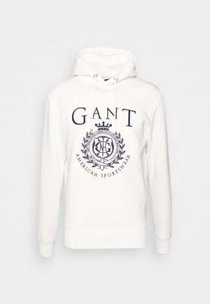 Biała bluza z kapturem z logo GANT i herbem w kolorze granatowym, z troczkami i długimi rękawami.