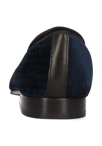 Donkerblauwe fluwelen schoen met een gestructureerd oppervlak, zwarte lederen accenten, platte hak en een strak design, geschikt voor formele kleding.