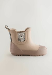 Cizmă de ploaie din cauciuc de culoare cămilă, cu talpă texturată, corp neted și căptușeală moale din material textil cu imprimeu animalier în interiorul gulerului.