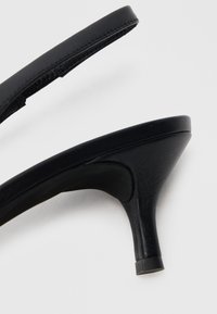 Μαύρα σανδάλια με ψηλό τακούνι, με λείο δερμάτινο επάνω μέρος, λεπ τό σχεδιασμό με λουράκια και λεπτομέρεια στο τακούνι που στενεύει. Υφή στην πέλμα για επιπλέον κράτημα.