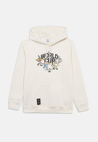 Hoodie crème avec une poche avant, présentant un design graphique coloré de la Coupe du Monde de la FIFA. Comprend une étiquette logo noire en bas.