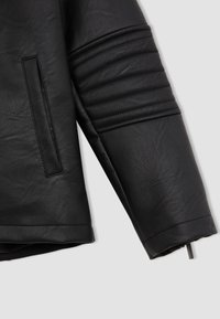 Manche de veste en cuir noir avec des panneaux texturés et une poche latérale. Présente une finition lisse et un design structuré avec une coupe droite.