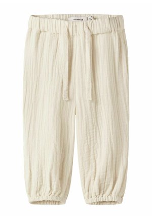 Kremowe spodnie dla niemowląt z elastycznym pasem, sznurkiem, fakturowaną tkaniną i elastycznymi ściągaczami przy nogawkach.