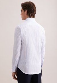 Koszula z długim rękawem w jasnoniebieskie i białe pionowe paski, wykonana z gładkiej tkaniny, z zaokrąglonym dołem i mankietami na guziki.