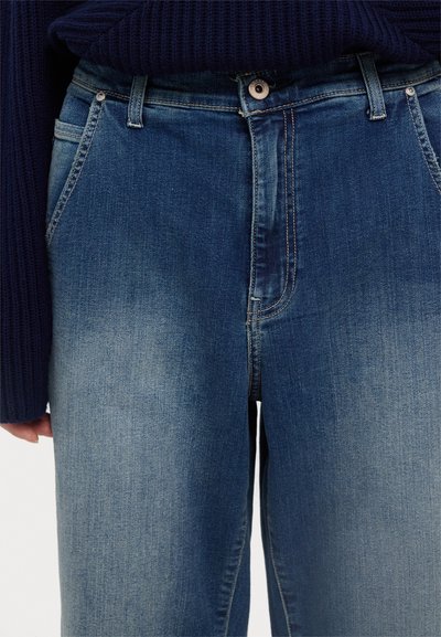 Jeans a gamba larga in denim azzurro chiaro con cuciture a contrasto, tasche anteriori e chiusura con bottone. Tessuto liscio, finitura leggermente sbiadita.