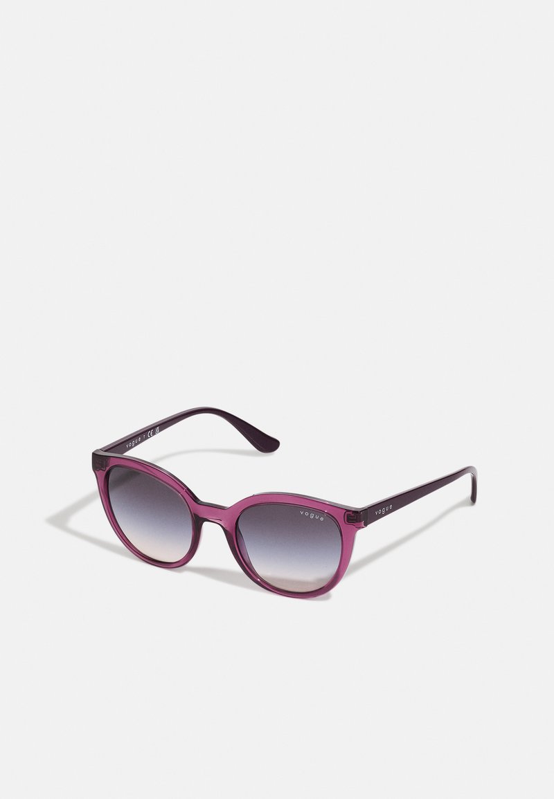 Ochelari de soare cu un gradient mov și un finisaj lucios, având rame cat-eye curbate și brațe întunecate elegante. Logo pe tâmple.