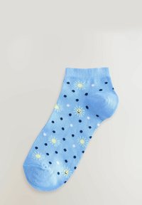 Ljusblå ankelsocka med gul sol och flerfärgade prickiga mönster. Ribbad fåll och slät textur. Perfekt för vardagsbruk.