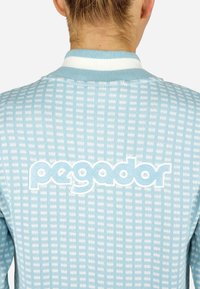 Svetlomodrá textúrovaná bunda so vzorom mriežky. Biela rebrovaná golier. Na chrbte je logo "pegador" vyšívané bielou niťou.