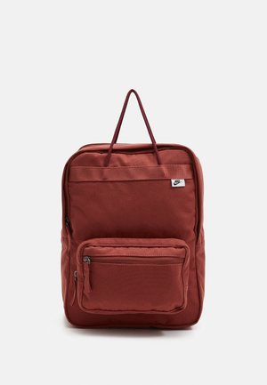 Rechteckiger, rostfarbener Rucksack mit vorderer Reißverschlusstasche, zwei oberen Tragegriffen und kleinem Nike-Logo oben rechts.