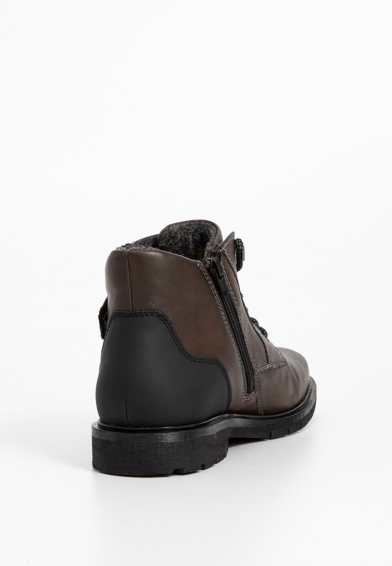 Botas de tobillo de cuero marrón con un tacón de goma negra texturizada, cierre de cremallera lateral y un suave forro gris visible alrededor del cuello.