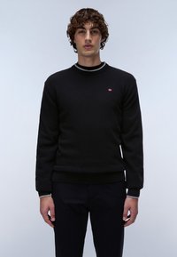 Czarny sweter dziany z okrągłym dekoltem, z szarym paskowanym kołnierzem. Mała emblemat na piersi. Teksturowana tkanina i ściągacz na dolnej krawędzi.