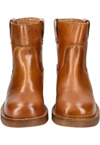 Bottes de cheville en cuir tan avec une surface lisse, un bout rond et des anses latérales pour un enfilage facile. Semelle en caoutchouc brun durable.