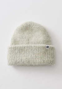 Light gray knit beanie with a ribbed texture and folded cuff. Features a small black and white logo tag. Soft, warm material.