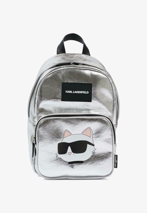 Sac à dos métallique argenté avec une poche avant arborant un chat blanc portant des lunettes de soleil noires et un patch logo noir "KARL LAGERFELD".