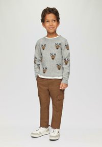Grauer Strickpullover mit Rentiermustern, braune Cargo-Hosen und weiße Sneaker. Der Pullover hat einen runden Halsausschnitt und lange Ärmel.