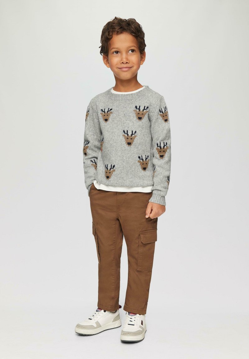 Grauer Strickpullover mit Rentiermustern, braune Cargo-Hosen und weiße Sneaker. Der Pullover hat einen runden Halsausschnitt und lange Ärmel.