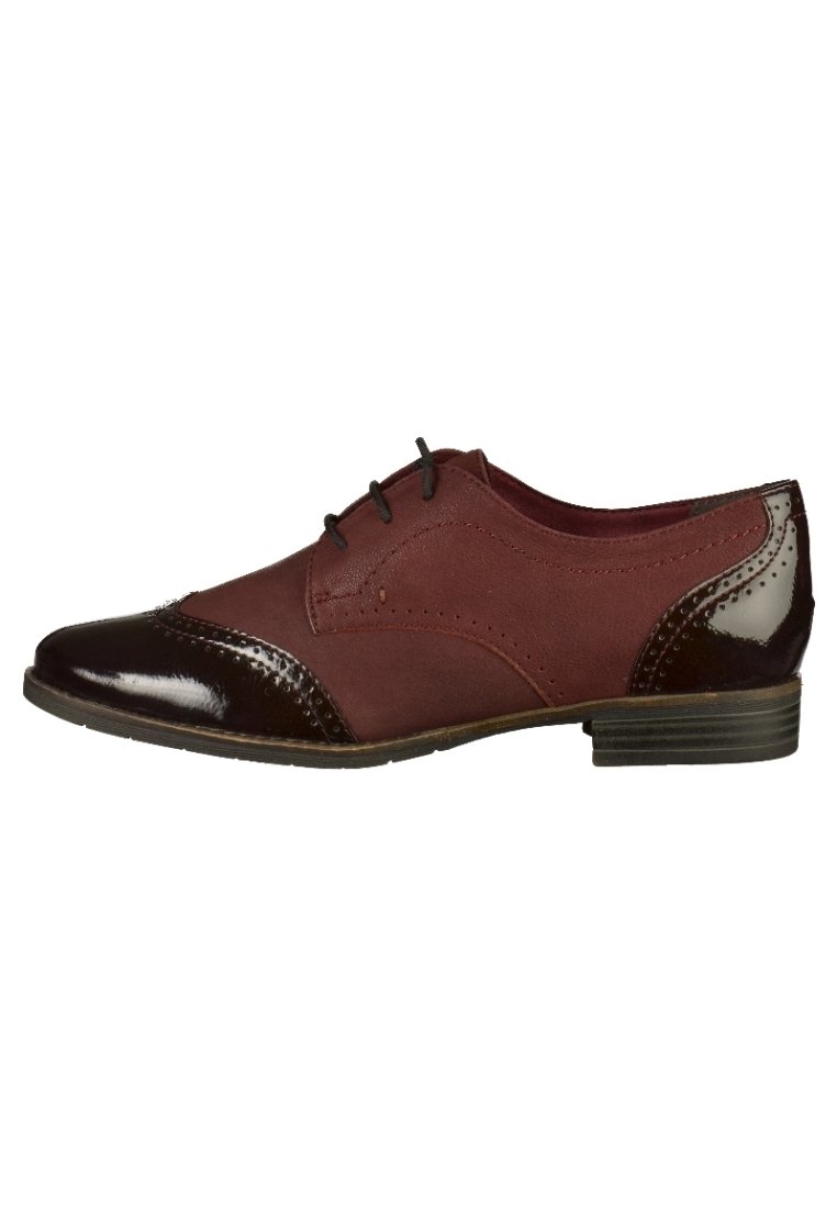 Chaussure en cuir bordeaux avec bout et talon en cuir marron foncé brillant, ornés de détails brogue et de trois œillets pour les lacets. Talon bas empilé.