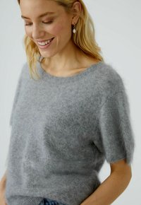 Grijze mohairmix trui met korte mouwen, ronde halslijn, zachte textuur en een subtiele fuzzy uitstraling. Geschikt voor lagen.
