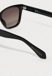 Óculos de sol pretos com lentes degradê, design retangular e acabamento brilhante. Nome da marca "PRIVÉ REVAUX" em dourado na haste.