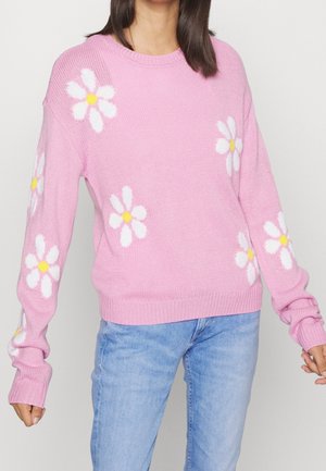 Rosa gestrickter Pullover mit langen Ärmeln, der weiße Gänseblümchen mit gelben Mittelpunkten zeigt. Gerippte Bündchen und Saum verleihen dem Design Textur.