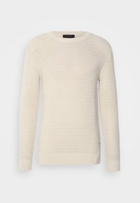 Pull en maille de coton couleur crème, présentant un design texturé, des manches longues et un col rond avec des poignets et un ourlet côtelés.