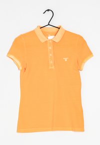 Orange polo skjorta med krage, korta ärmar, tvåknappars placket och en liten logotyp på bröstet. Strukturerad bomullstyg.