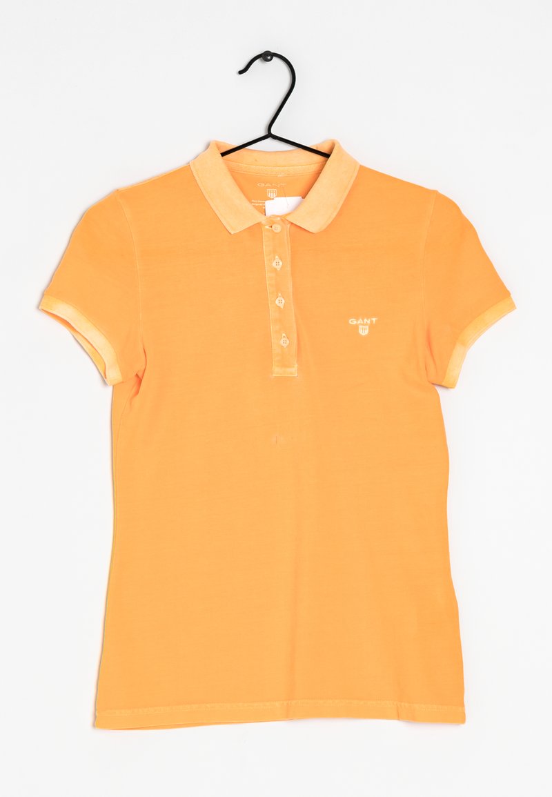 Orange polo skjorta med krage, korta ärmar, tvåknappars placket och en liten logotyp på bröstet. Strukturerad bomullstyg.