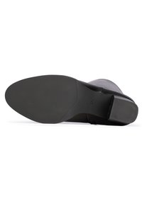 Stivale in pelle nera con tomaia liscia, punta rotonda e suola in gomma testurizzata. Tacco robusto e design flessibile per il comfort.