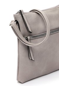 Graue Lederhandtasche mit glatter Oberfläche, ausgestattet mit einem Reißverschluss, einem abnehmbaren Tragegurt und kontrastierenden schwarzen Akzenten.