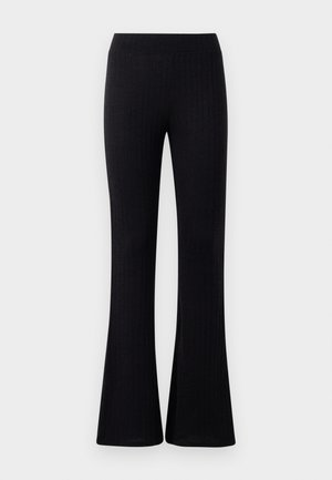 Calças pretas de malha com cintura elástica, apresentando um acabamento texturizado e bainha flare que adiciona uma silhueta fluida.