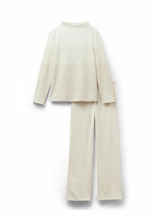 Set di abbigliamento da casa a due pezzi color crema, composto da una maglietta a maniche lunghe con motivo di fiocchi di neve e pantaloni coordinati con vita elasticizzata in morbido tessuto.