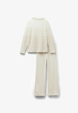 Cremefarvet to-delt loungewear sæt med en langærmet top med snefnugsmønster og matchende elastisk talje bukser i blødt stof.