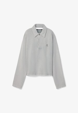 Pull-over gris clair à manches longues avec un col large, une patte de boutonnage partielle et un petit logo sur la poitrine gauche.