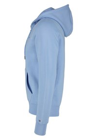 Sudadera azul claro hecha de tejido suave, con un bolsillo frontal, capucha con cordón y puños acanalados. Diseño sencillo con un detalle de logo.