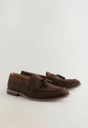 Mocasines de ante marrón con un detalle de lazo, con punta redonda y superficie texturizada. Tacón bajo apilado y detalle de costura en contraste.