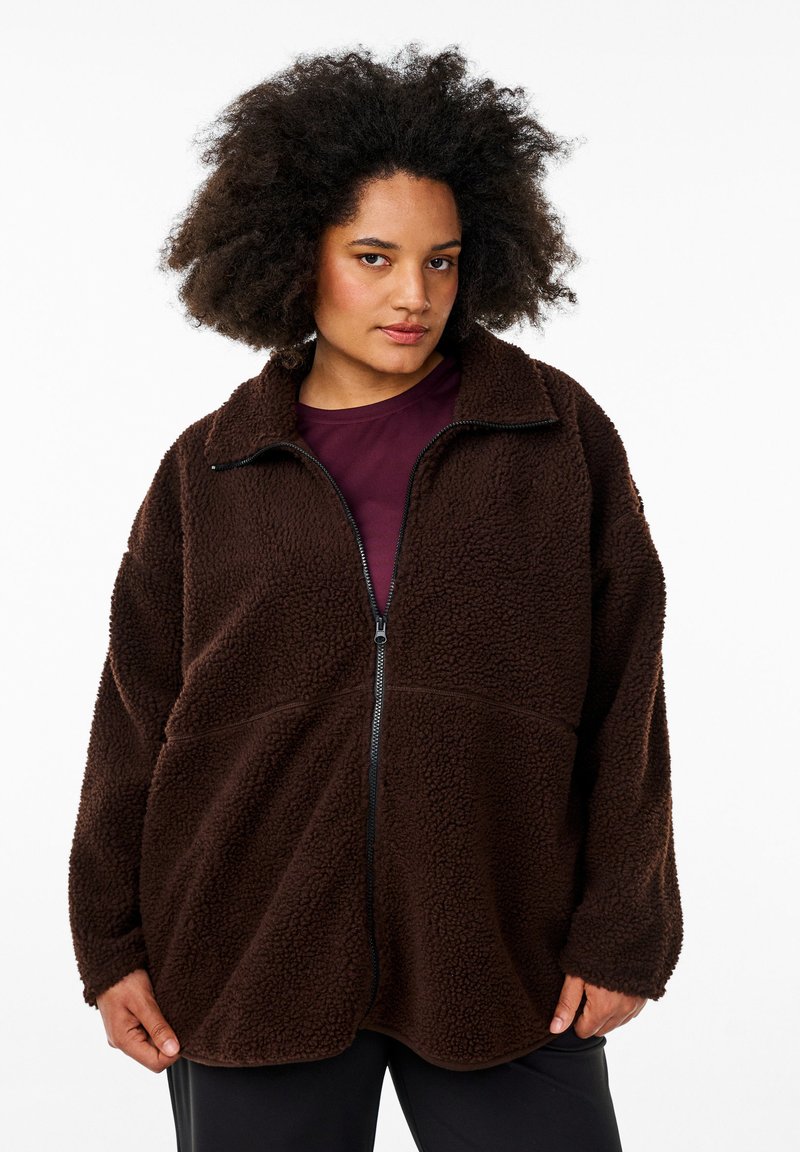 Braune Fleecejacke mit hohem Kragen, durchgehendem Reißverschluss und lockerer Passform. Verfügt über ein strukturiertes Material und kontrastierende schwarze Reißverschlussdetails.