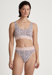 Lichtroze beha en bijpassende string, met een subtiele bloemenpatroon in donkerdere tinten. Zacht, rekbaar materiaal met een brede elastische tailleband.