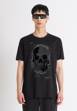 Camiseta de algodón negra con un gráfico de calavera pixelada en tonos grises. Diseño de cuello redondo, mangas cortas y corte relajado.