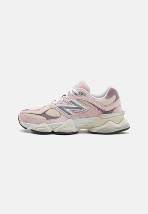 Baskets New Balance roses et beiges avec lacets blancs, panneaux en mesh et semelle beige épaisse, vues de côté sur fond blanc.