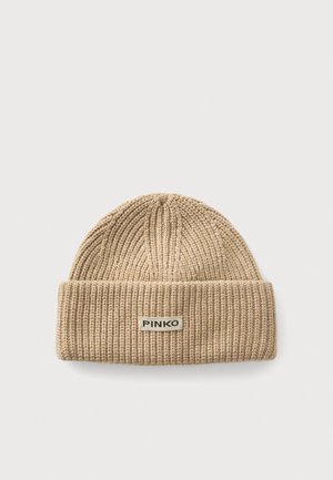 Bonnet beige en maille côtelée avec revers plié, featuring une étiquette rectangulaire avec le nom de la marque "PINKO" sur un fond clair.