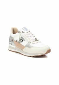 Zapatilla con upper de cuero blanco y beige, acentos plateados, detalles perforados y una media suela texturizada. Presenta cordones y una cremallera lateral.