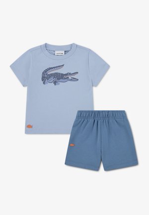 T-shirt en coton bleu clair avec un motif de crocodile, accompagné d'un short à taille élastique assorti ; les deux présentent un petit logo.