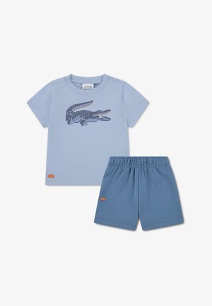 T-shirt en coton bleu clair avec un motif de crocodile, accompagné d'un short à taille élastique assorti ; les deux présentent un petit logo.